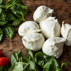 AMB buffalo mozzarellas on a wooden board with fresh basil