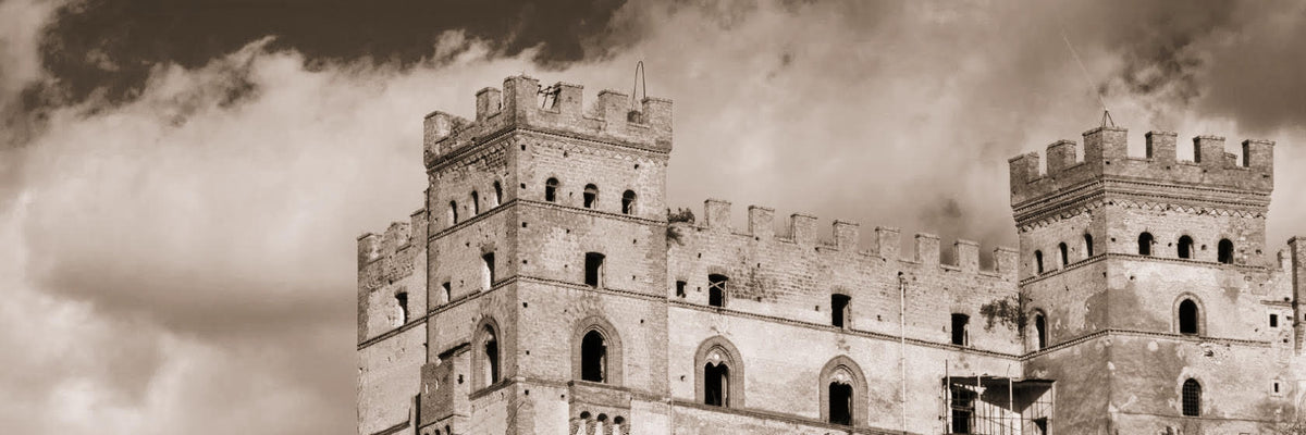 The crenellated towers of Battipaglia Castle against a cloudy sky, sepia photo