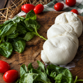 La Treccia di Bufala AMB sul tagliere con basilico e pomodorini